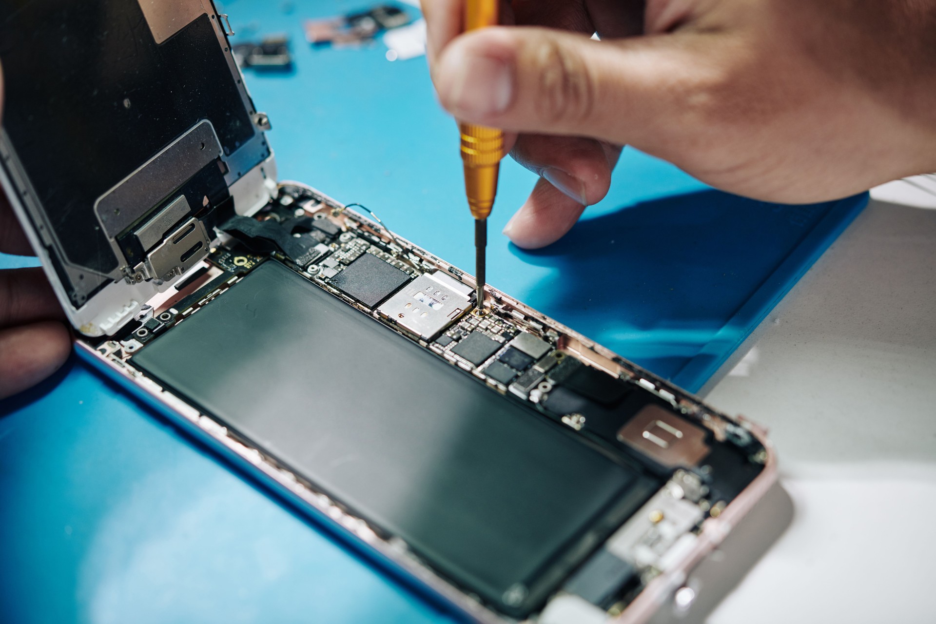 Smartphone repairman man securing a screw